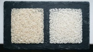 Side-by-side comparison of basmati rice and long grain white rice on a dark slate surface