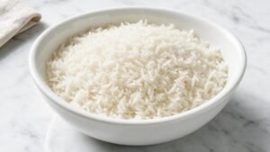 Top-down view of C-9 long-grain white rice in a white ceramic bowl on marble